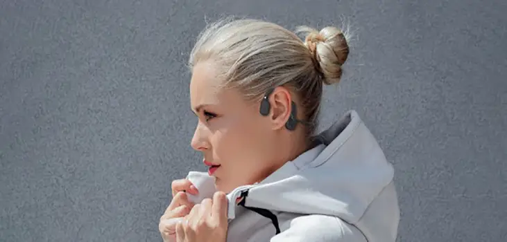 Woman enjoying music using Inductivv headphones while staying alert to their surroundings.